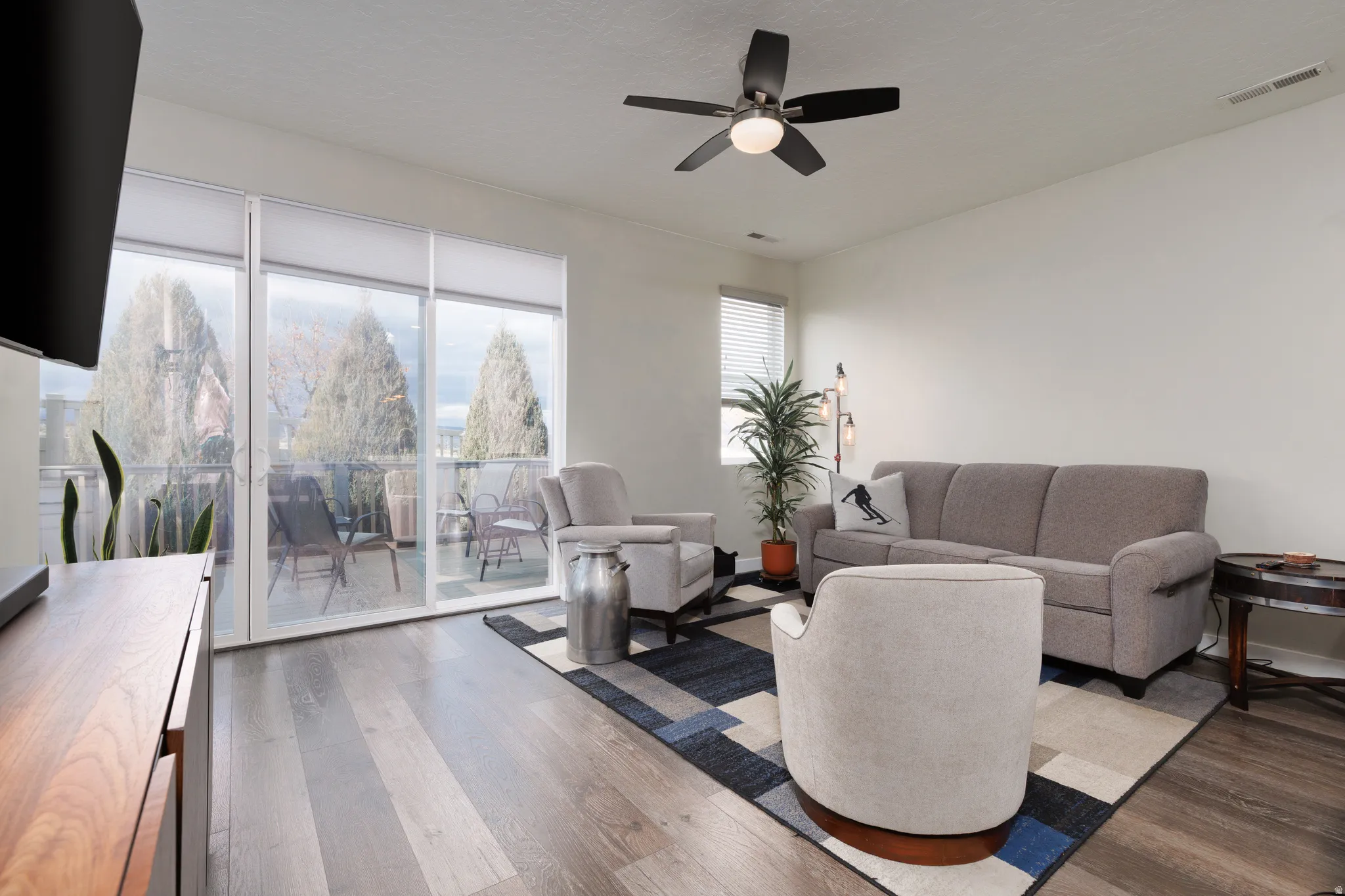 Living room with dark wood-type flooring, ceiling fan, and a textured ceiling