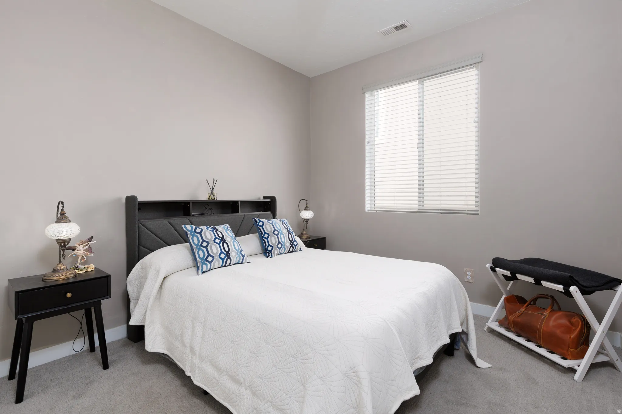 Second bedroom with light carpet and custom blinds.
