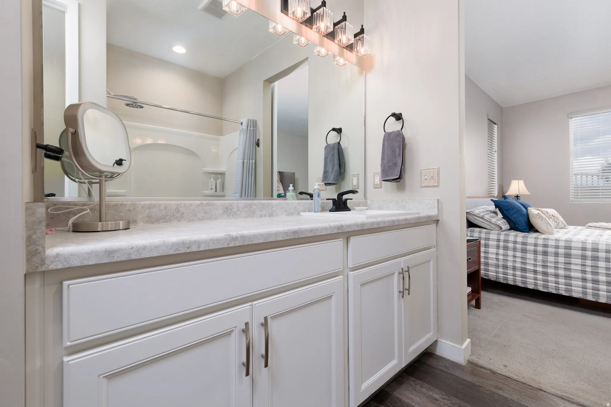 En suite bathroom with vanity, oversize shower, and dark wood finished floors