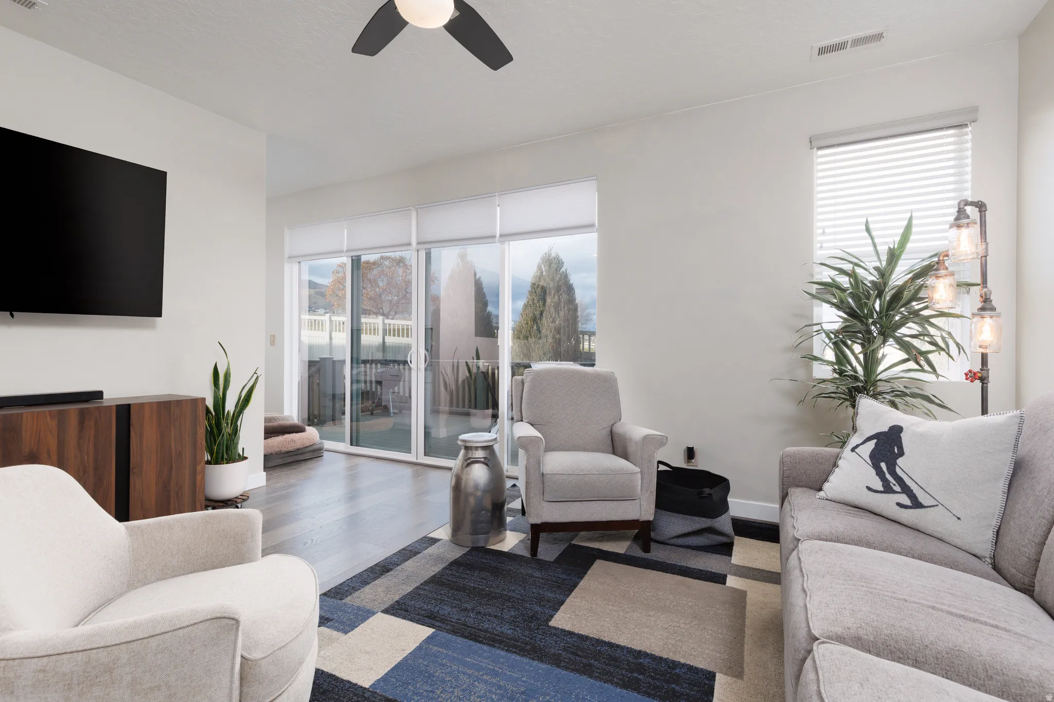 Living area with wood finished floors and ceiling fan and 12 foot sliders to custom Trex deck.