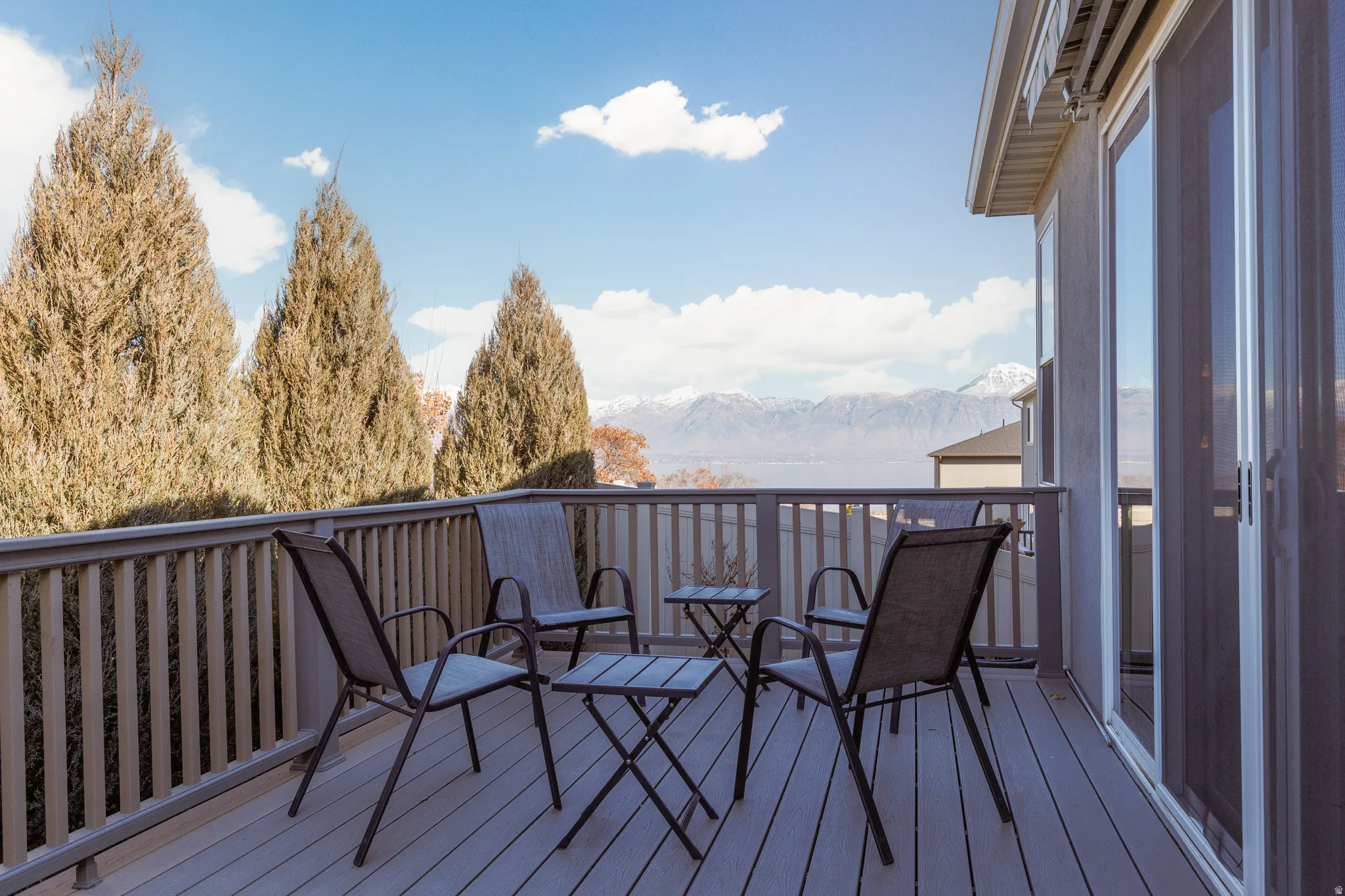 Deck featuring stunning views of the Wasatch Mountains, Utah Lake, the valley with privacy evergreens.