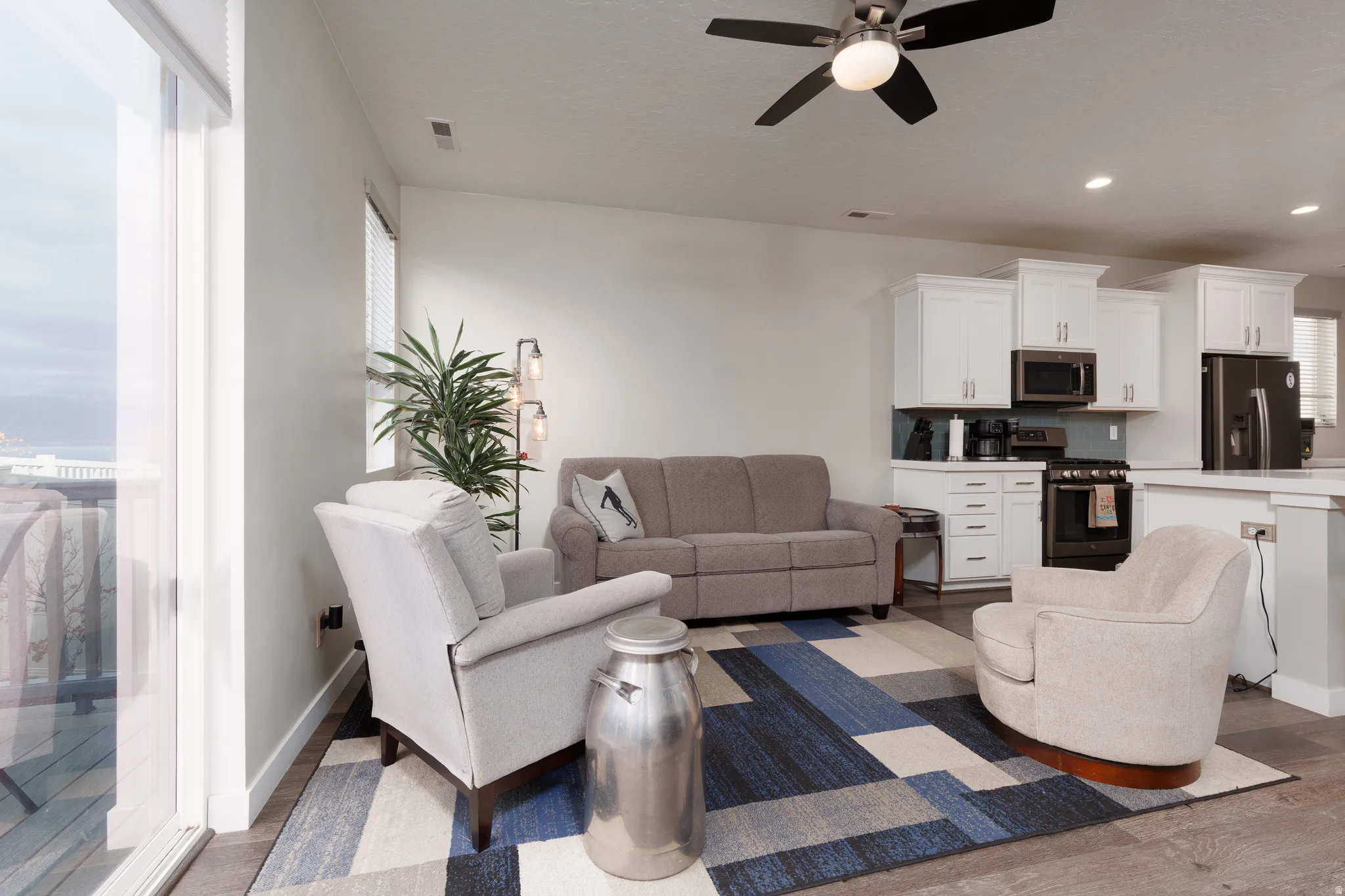 Living area featuring light wood-style flooring and ceiling fan, looking from dedicated office space.