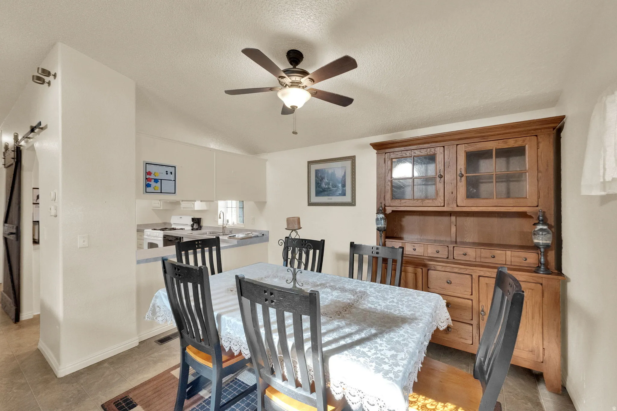 Dining area featuring a ceiling fan and a textured ceiling