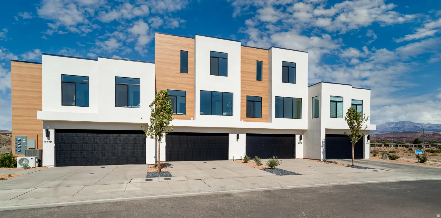 Contemporary house with stucco siding, driveway, and a garage