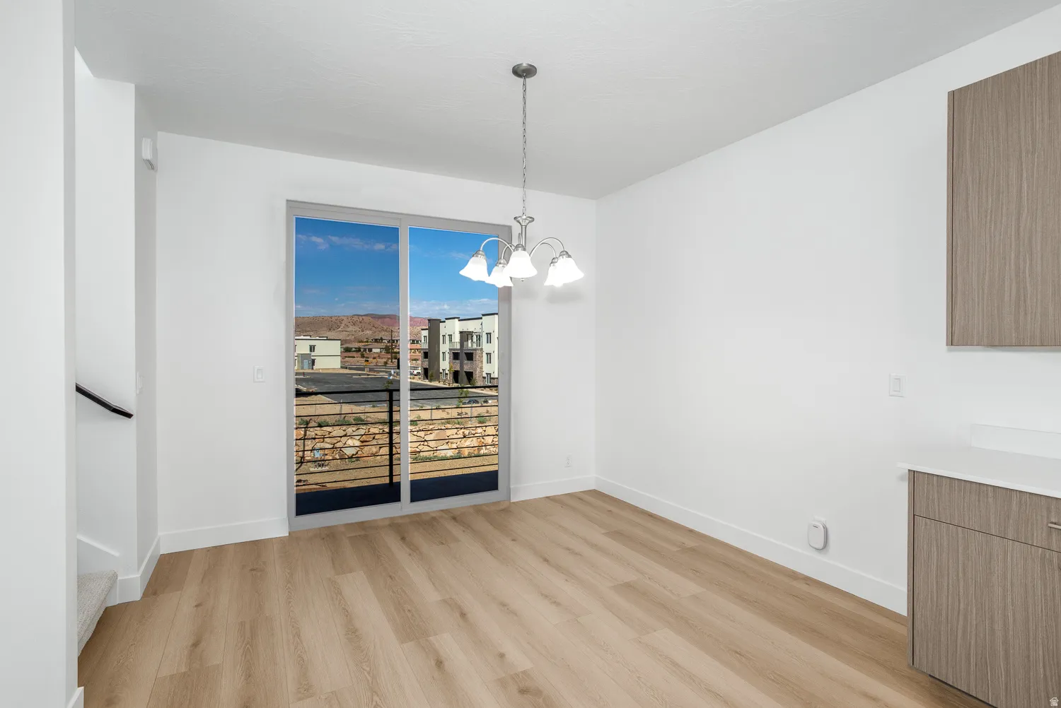 Unfurnished dining area with light wood finished floors and a chandelier