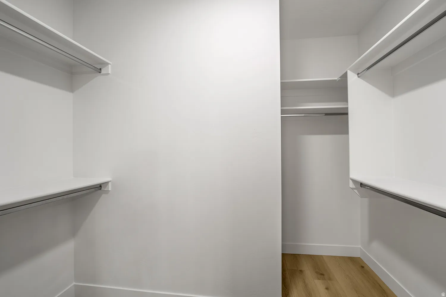 Walk in closet with light wood-style floors