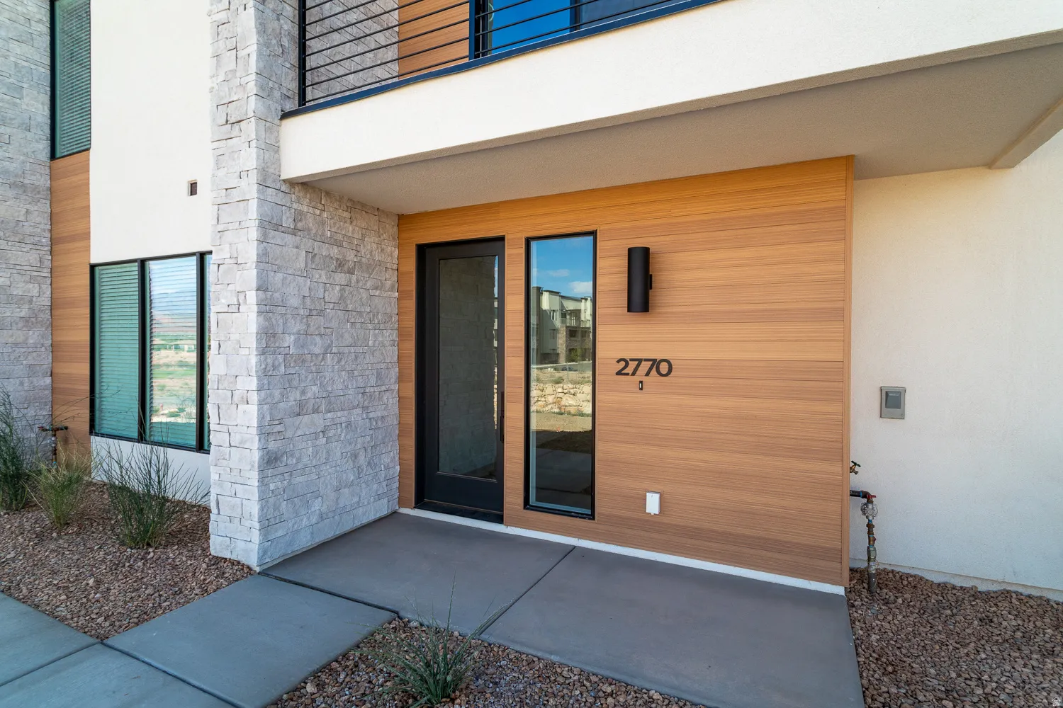 View of exterior entry featuring stone siding and stucco siding