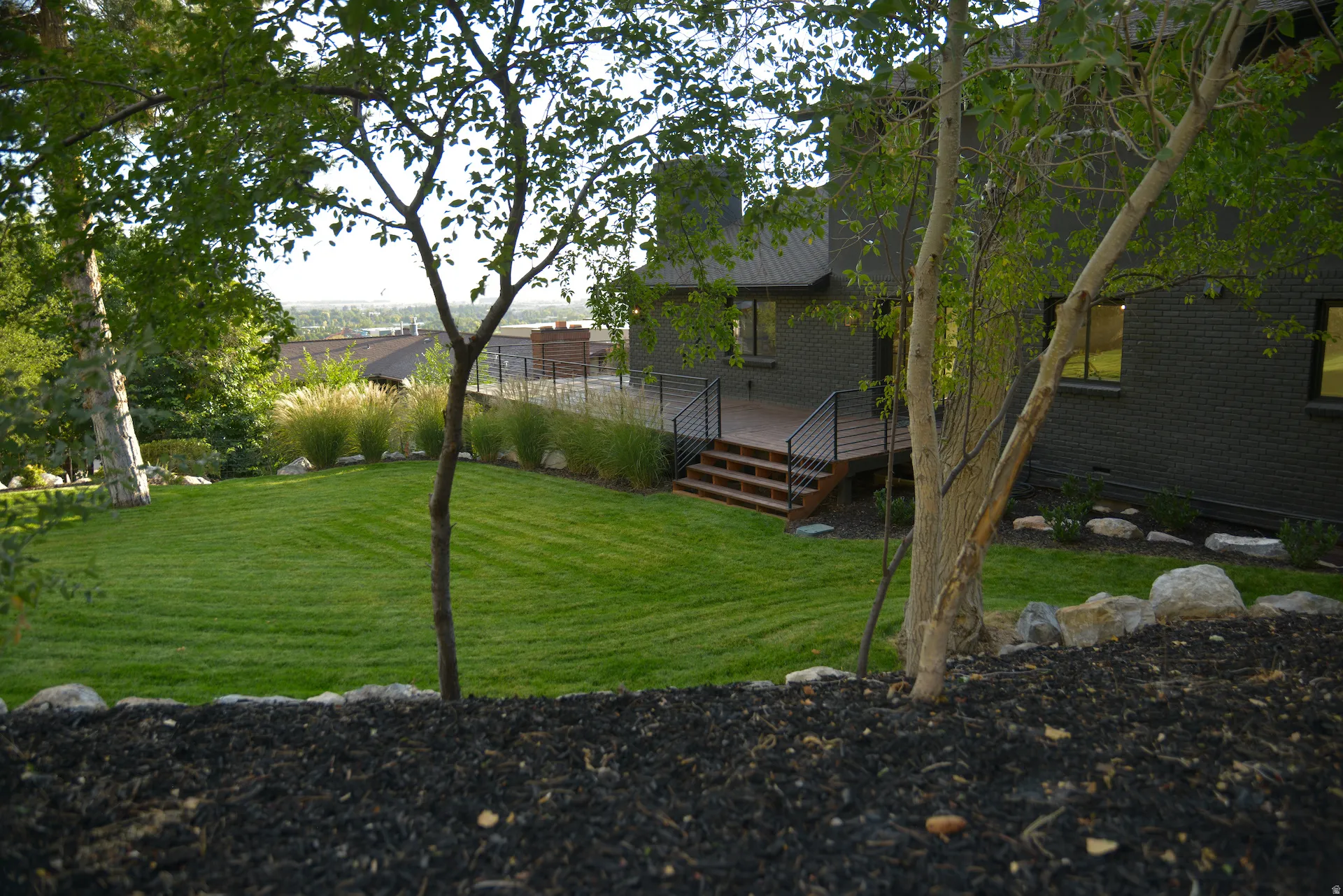 View of grassy yard featuring a deck