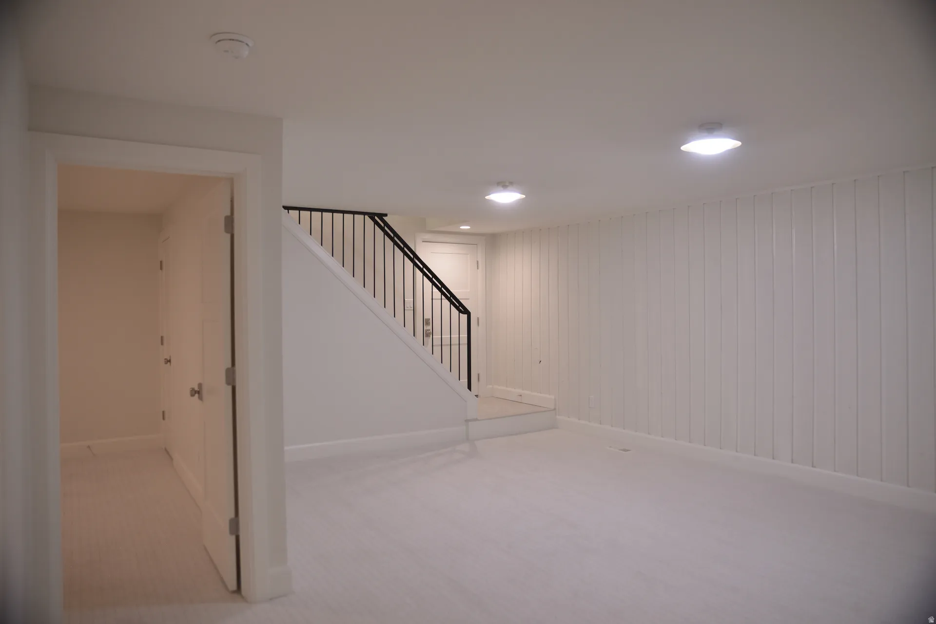 Below grade area with stairs, light colored carpet, and recessed lighting