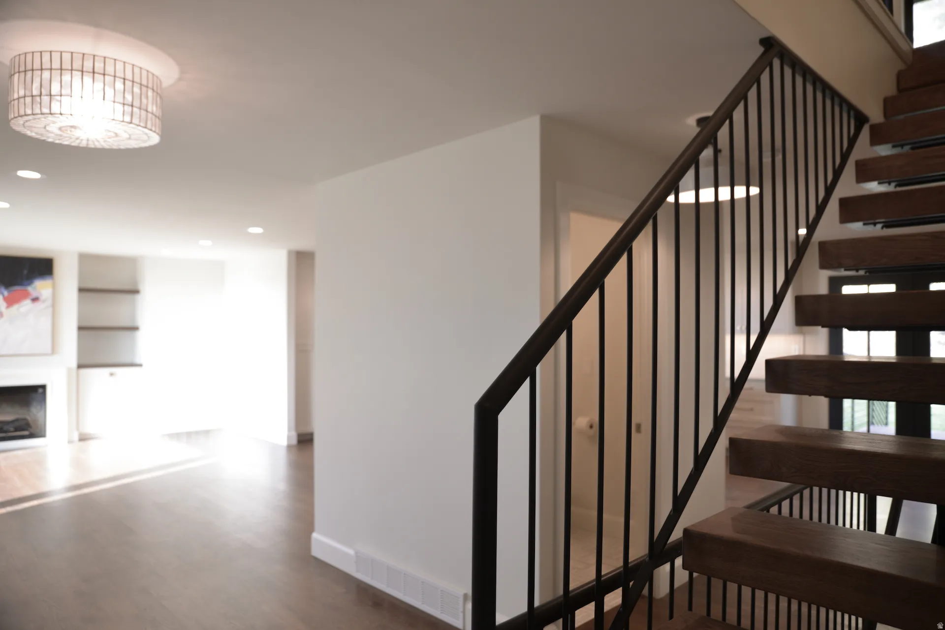 Stairs with built in features, a fireplace, wood finished floors, and recessed lighting