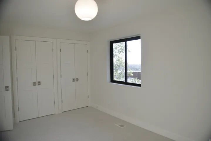 Unfurnished bedroom featuring two closets and carpet