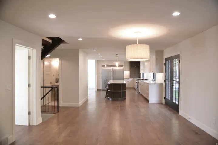 Kitchen featuring white cabinets, recessed lighting, hanging light fixtures, stainless steel built in fridge, and a center island