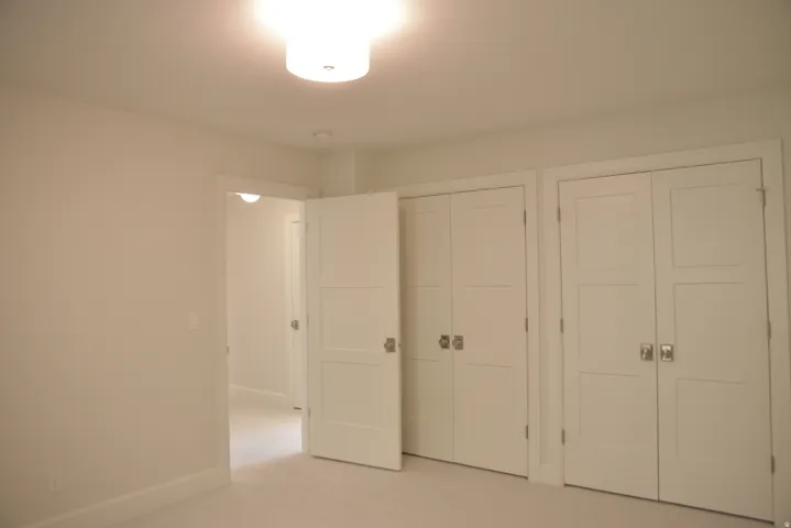 Unfurnished bedroom featuring two closets and carpet floors