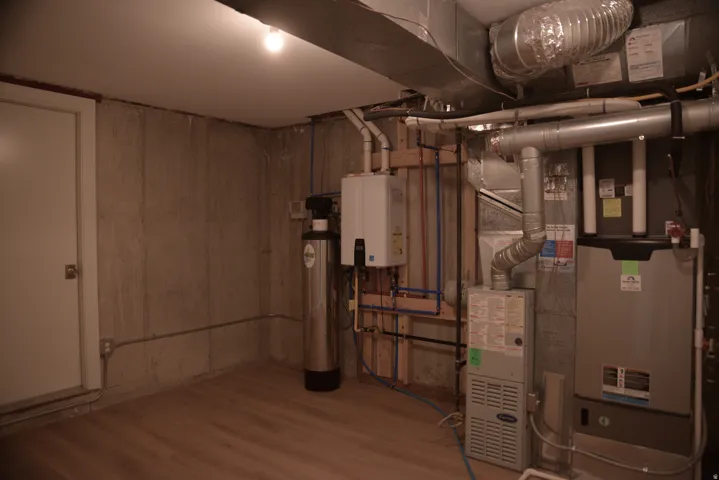 Utility room featuring heating unit and water heater