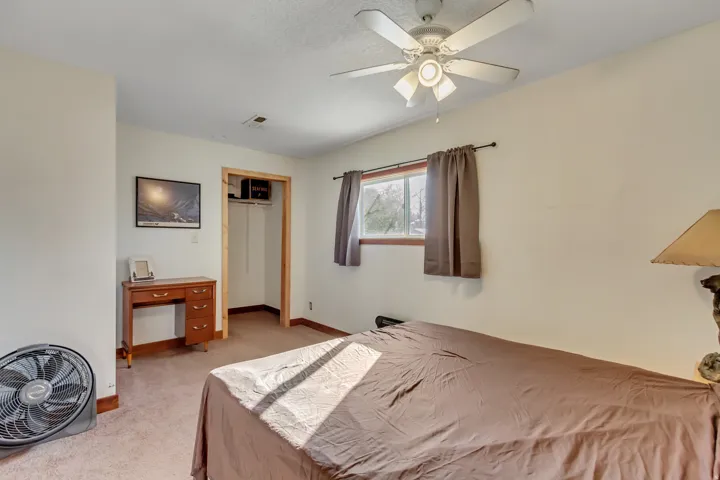 Bedroom featuring a closet, a ceiling fan, and light colored carpet