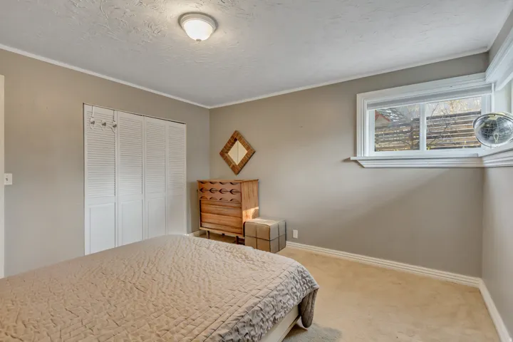 Bedroom with carpet flooring, a textured ceiling, a closet, and ornamental molding
