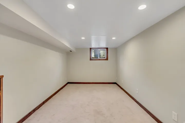 Below grade area featuring light colored carpet and recessed lighting