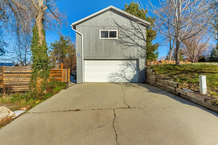 View of side of home with driveway and a garage