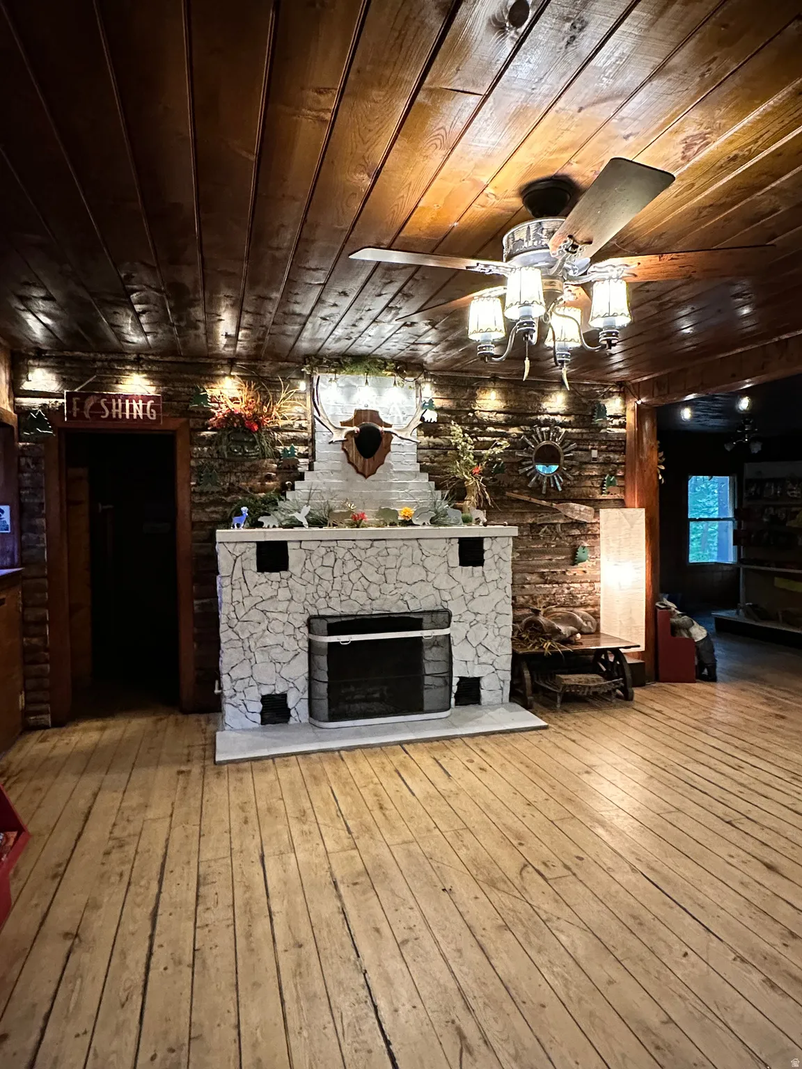 Unfurnished living room with wooden ceiling, light wood finished floors, and a fireplace