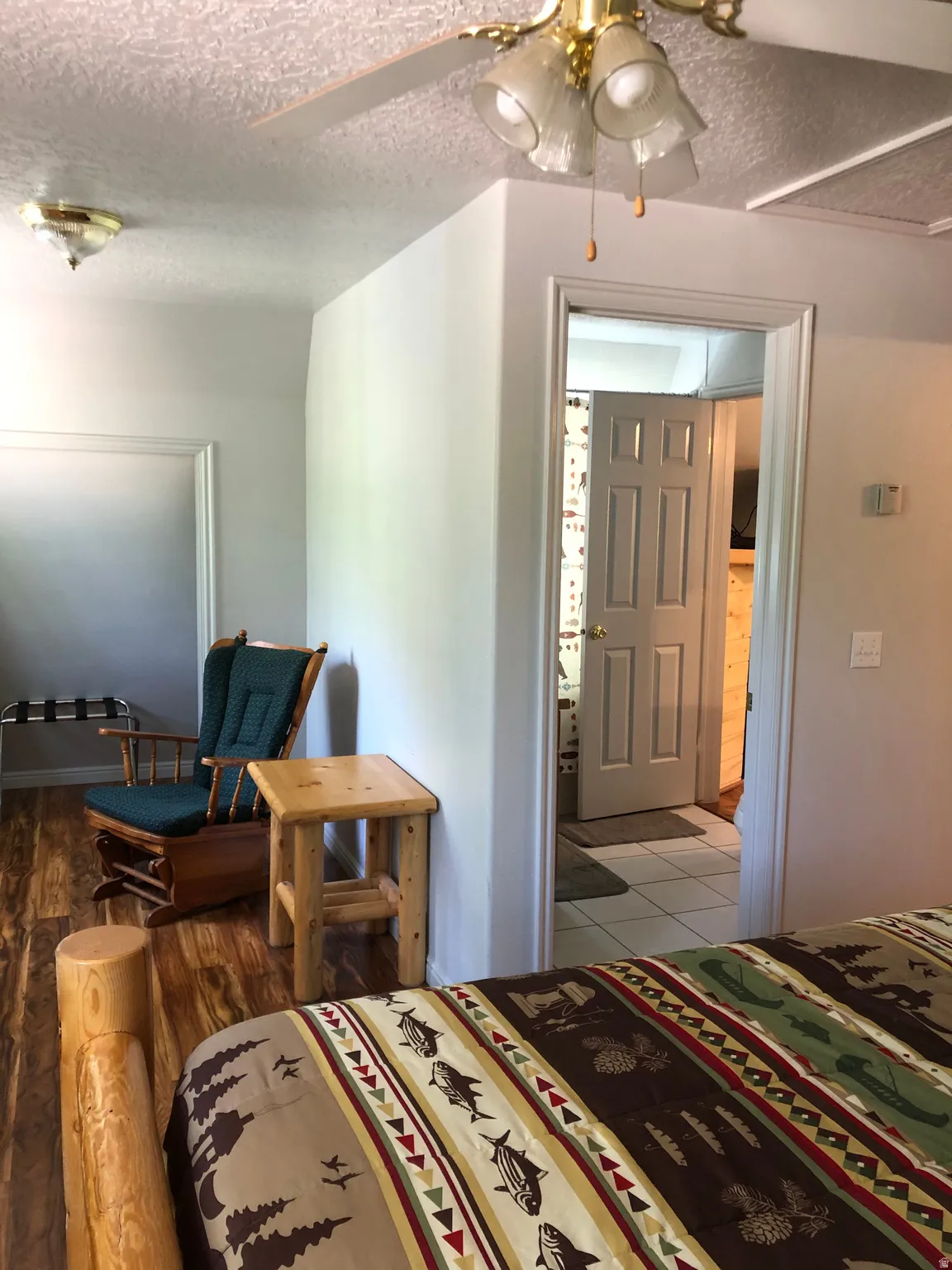 Bedroom with a textured ceiling and a ceiling fan