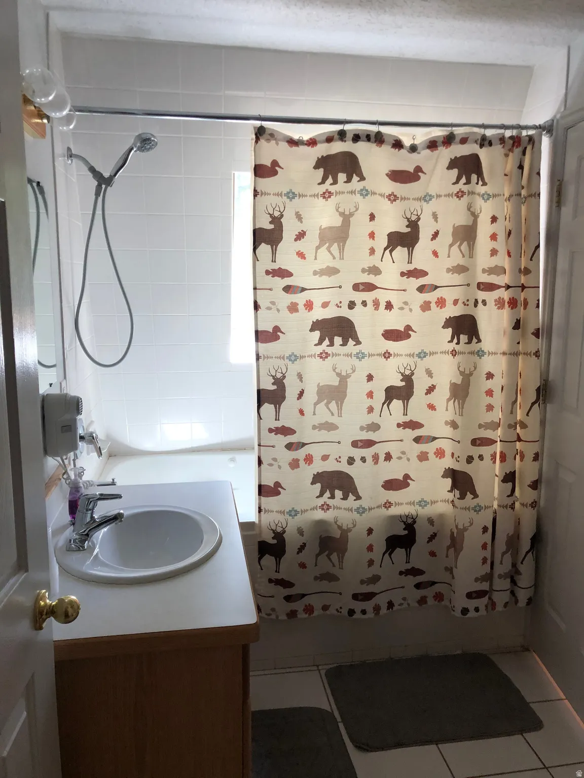 Full bathroom with vanity, shower / tub combo with curtain, and tile patterned flooring
