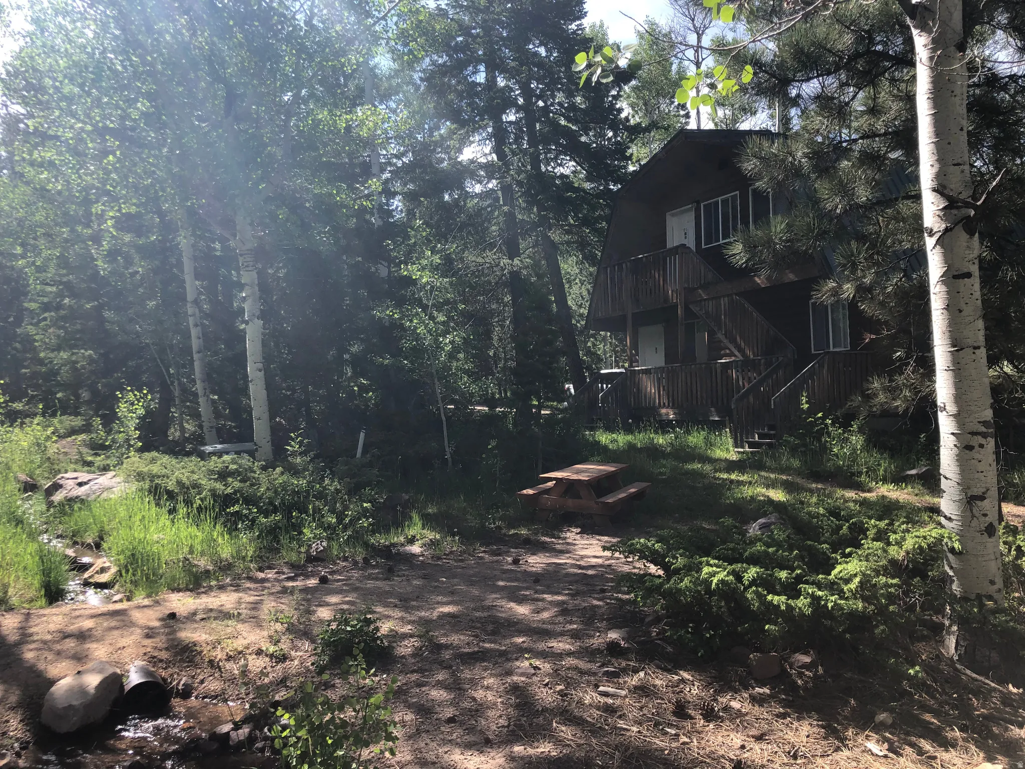 View of yard with a balcony, stairway, and a wooded view