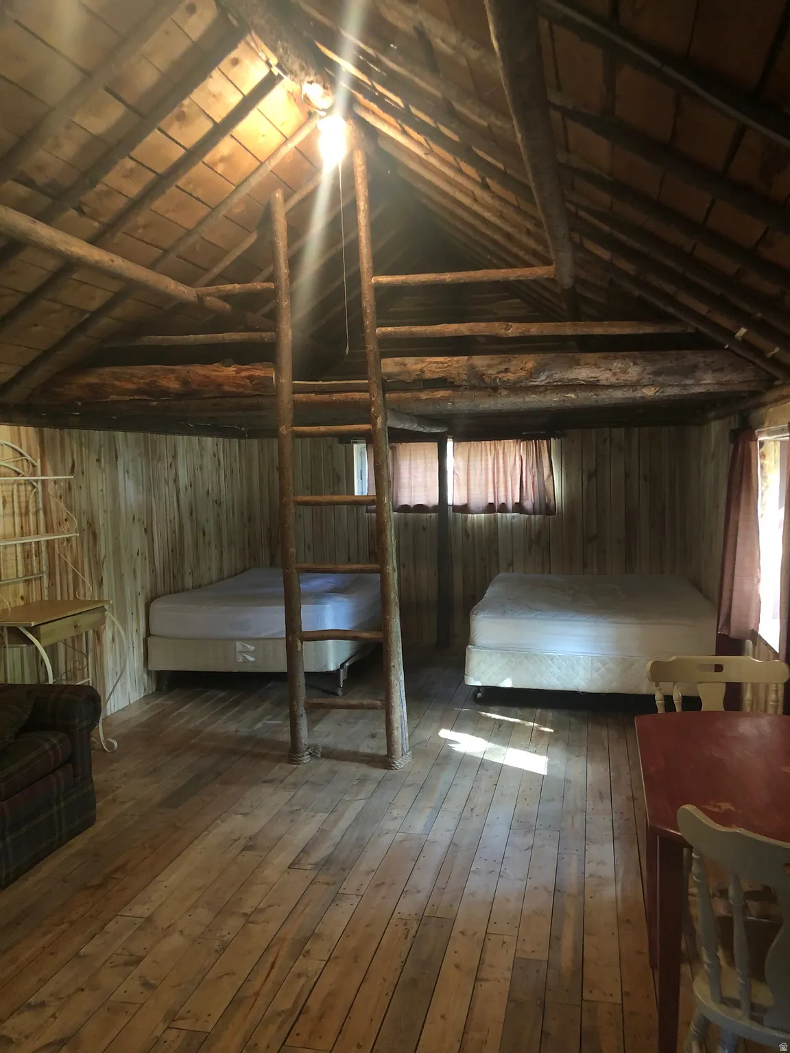 Unfurnished bedroom featuring wood-type flooring, vaulted ceiling, wooden ceiling, and wood walls