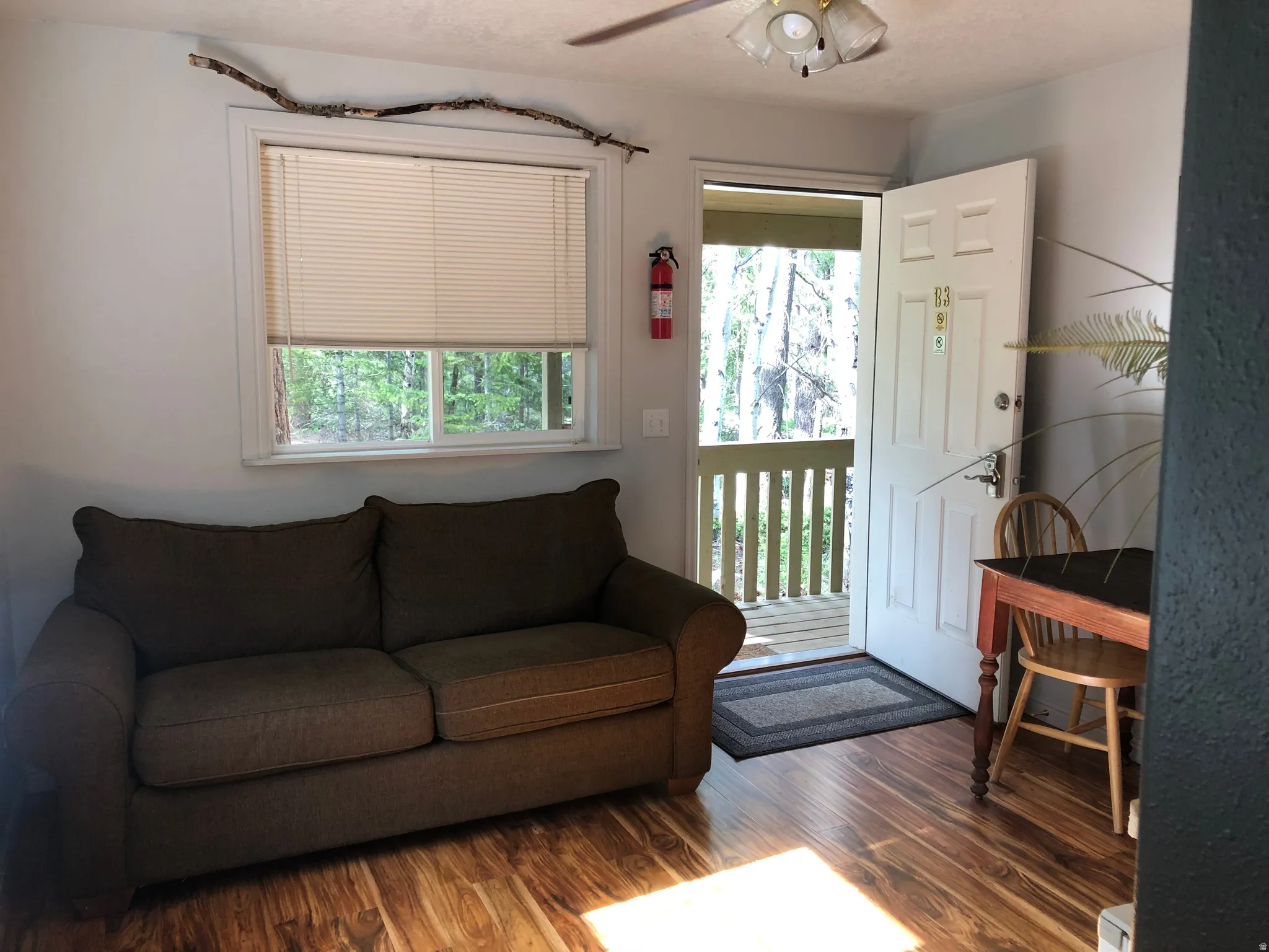 Living room with plenty of natural light, wood finished floors, and ceiling fan