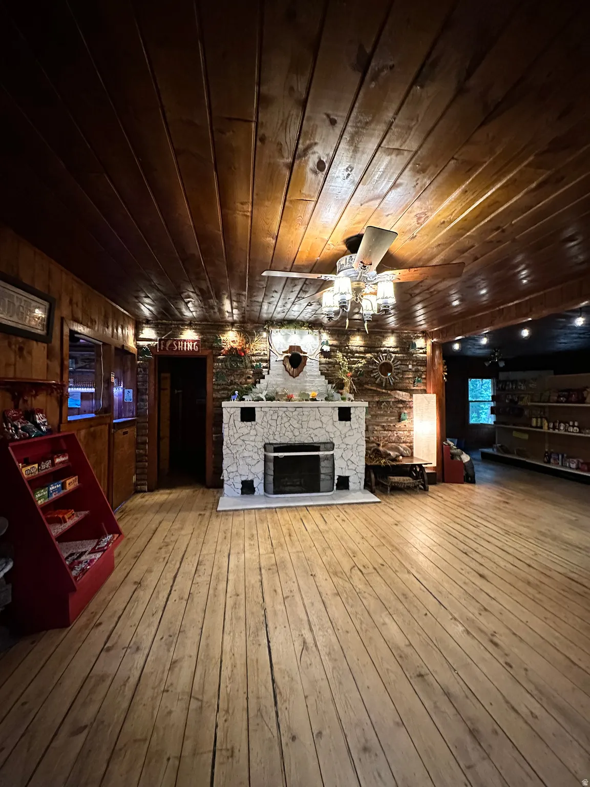 Unfurnished living room with wooden ceiling, a fireplace, hardwood / wood-style flooring, and wooden walls