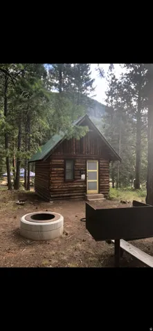 View of home's exterior with log siding and a fire pit