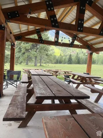 Expansive outdoor covered area featuring exposed wood beams, a metal roof, and string lighting