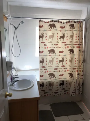 Full bathroom with vanity, shower / tub combo with curtain, and tile patterned flooring