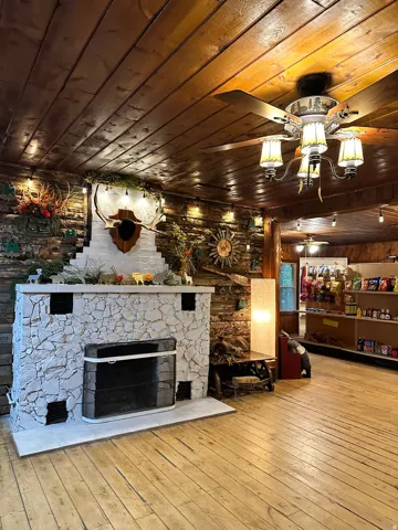Living room featuring wooden ceiling, wood-type flooring, and a fireplace