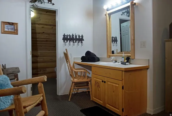 Bathroom with vanity and dark colored carpet