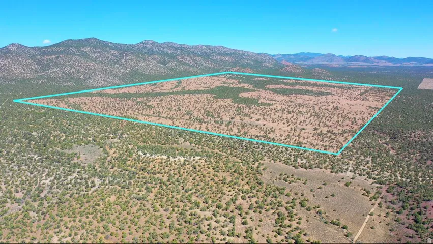 Expansive land parcel featuring natural terrain and distant mountainous backdrop