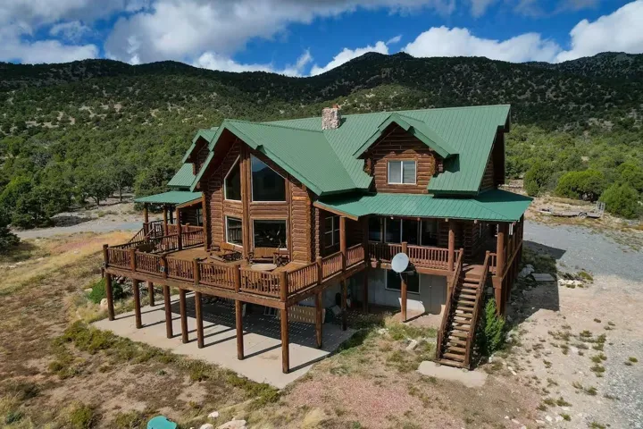 Rear view of property featuring a chimney, a metal roof, a mountain view, and a porch