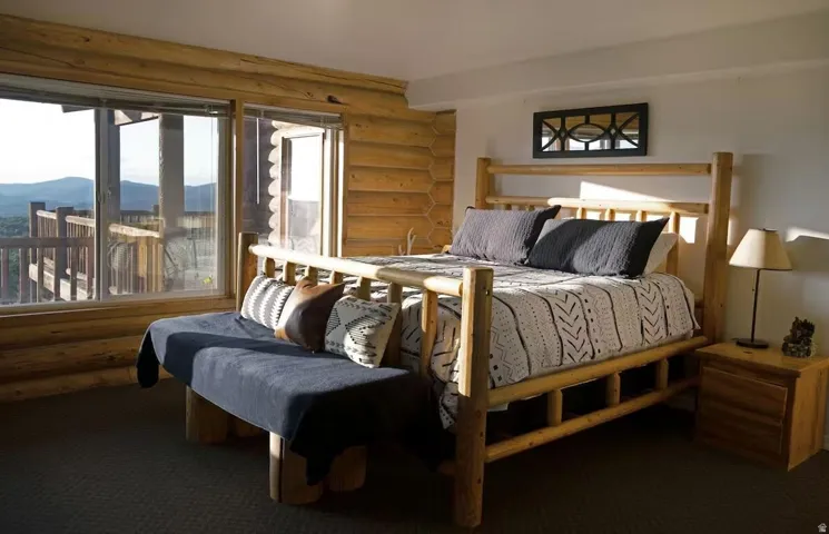 Bedroom featuring rustic walls, carpet flooring, and a mountain view