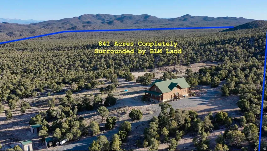 Expansive 841-acre property featuring a large structure with a green roof, surrounded by extensive natural terrain and distant mountains