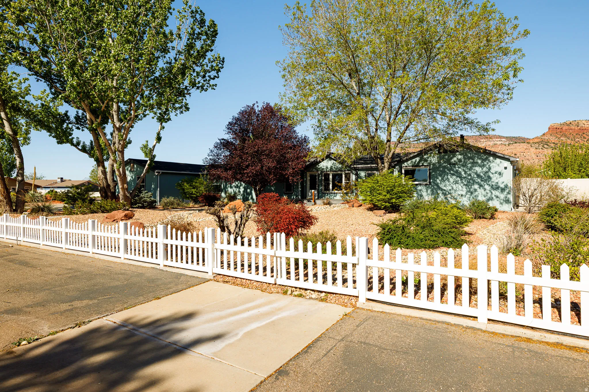 View of property hidden behind natural elements with a fenced front yard