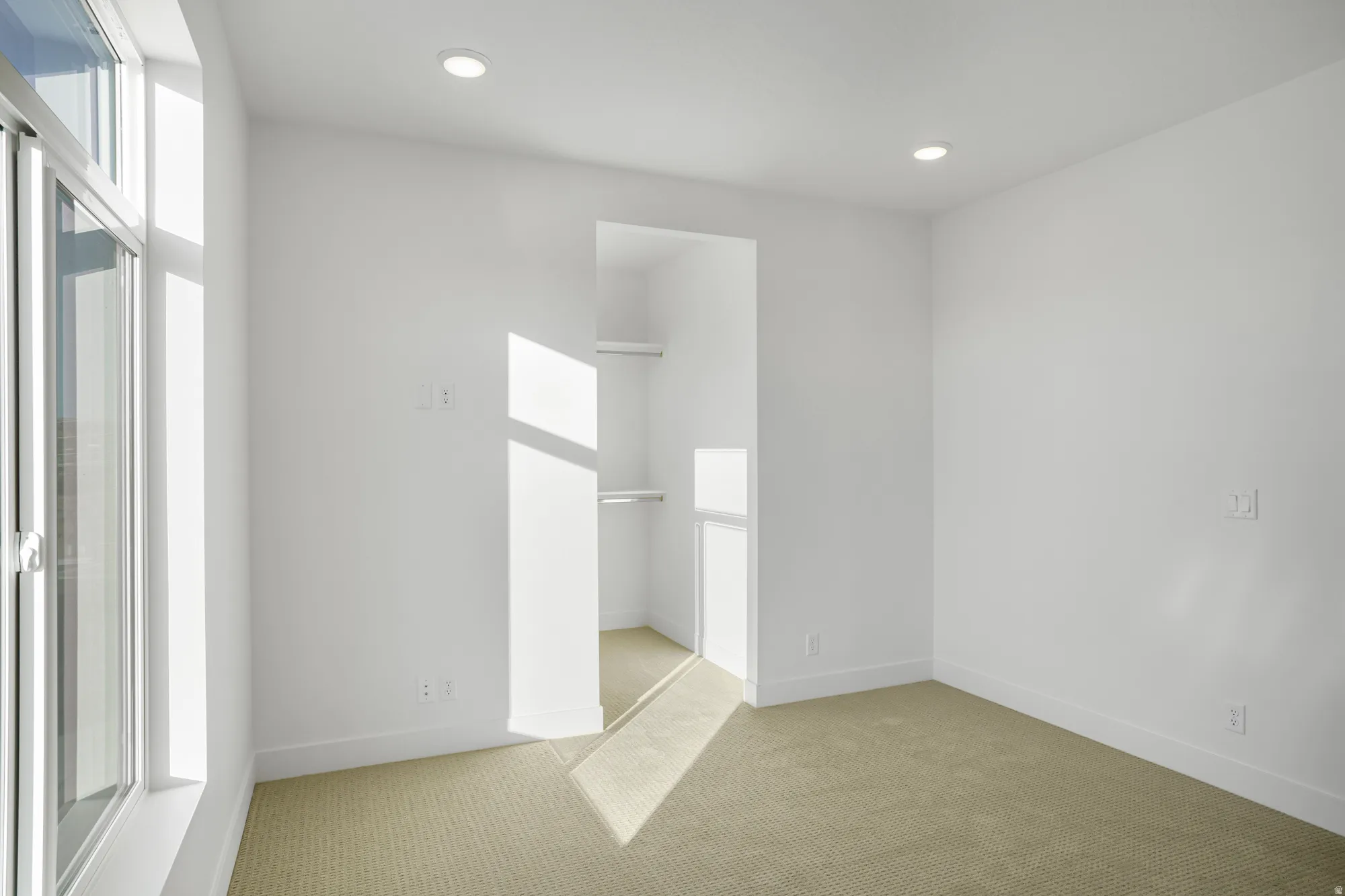 Carpeted room featuring a built-in closet with shelving and hanging rods