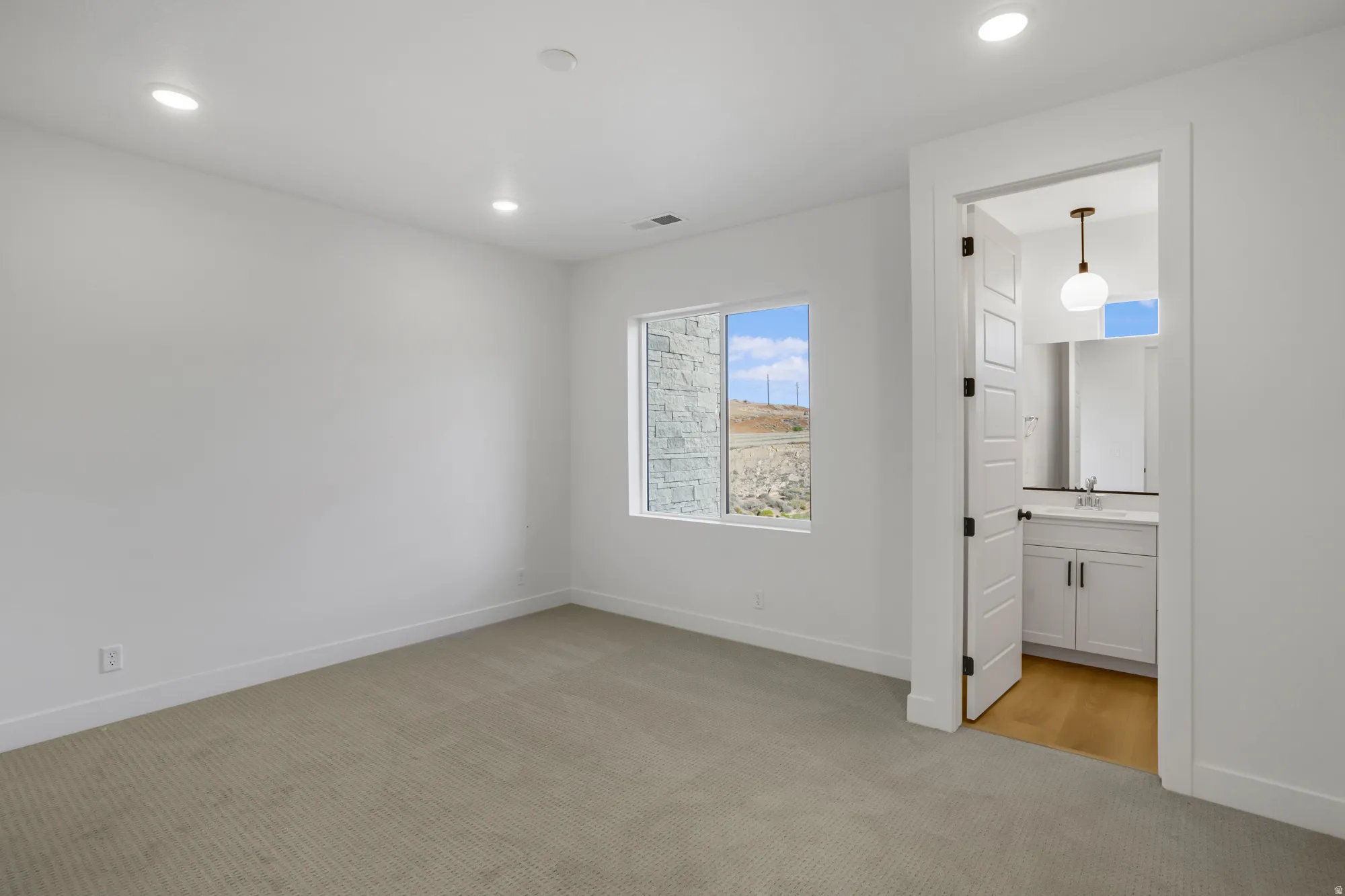 Spacious room with recessed ceiling lighting, a large window, and carpet flooring