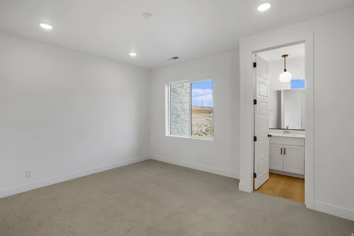Spacious room with recessed ceiling lighting, a large window, and carpet flooring