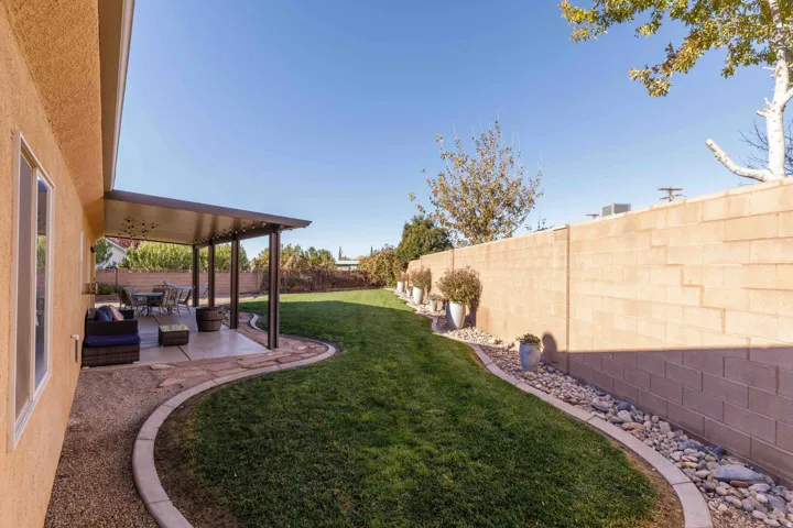 Fenced backyard featuring a patio, an outdoor hangout area, and ceiling fan