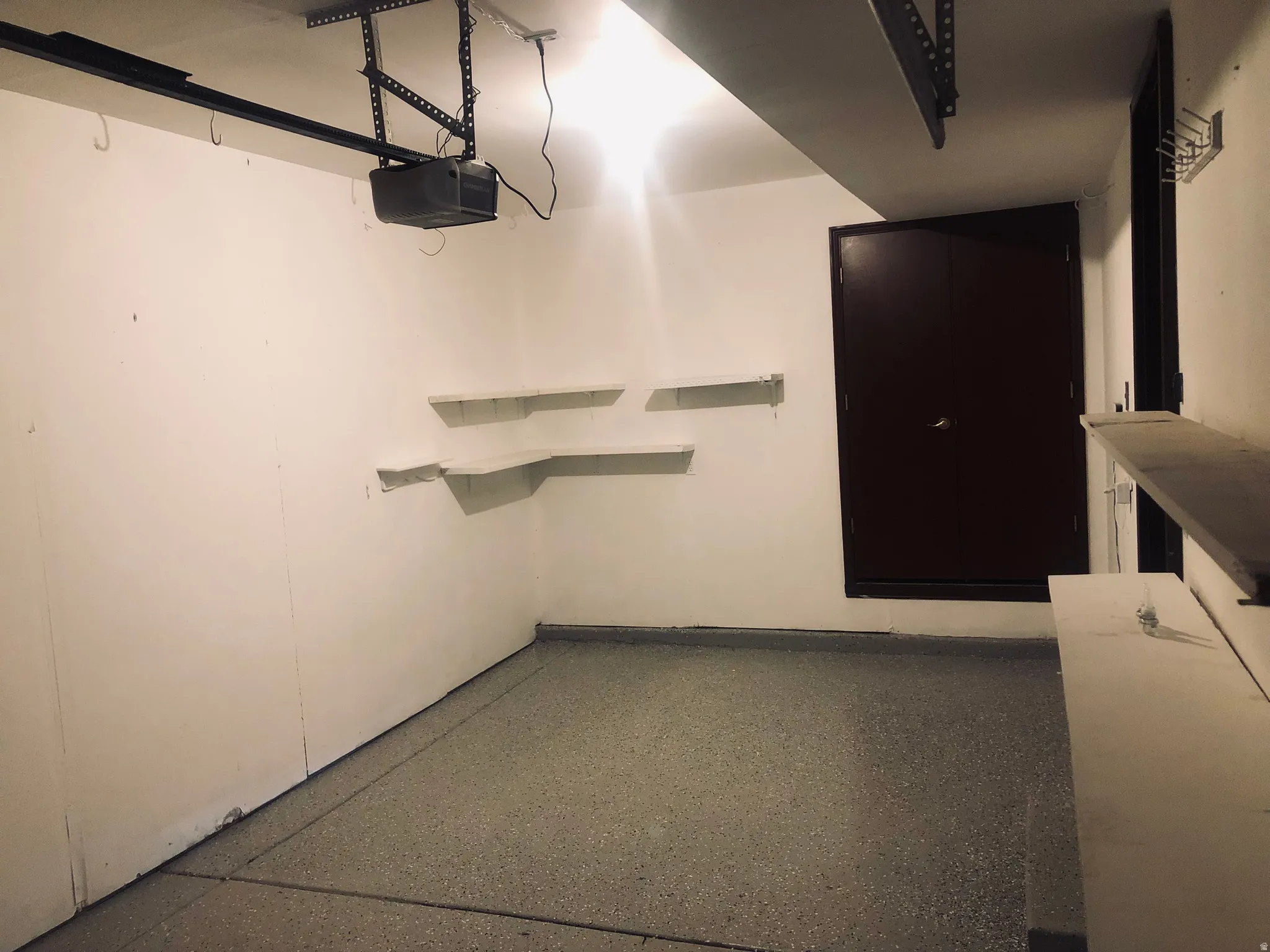 Garage featuring a garage door opener and baseboards