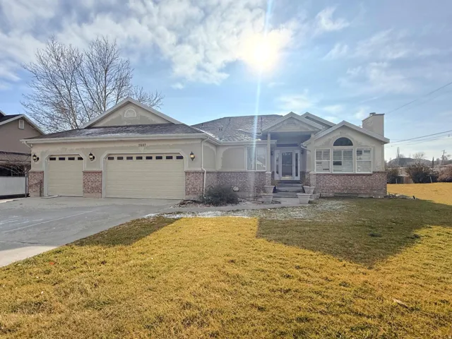 Ranch-style home with brick siding, a front lawn, a garage, concrete driveway, and a chimney