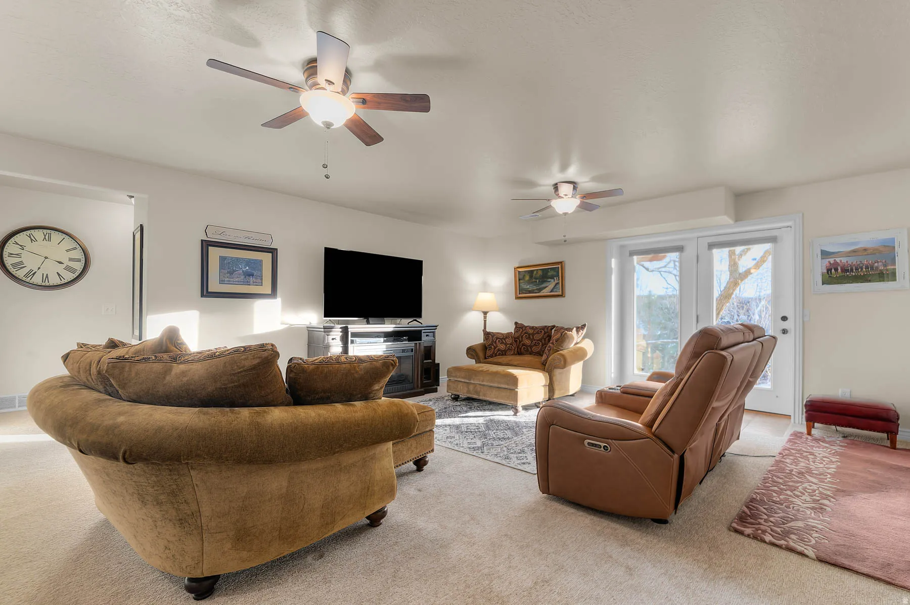 Living area featuring light colored carpet and ceiling fan