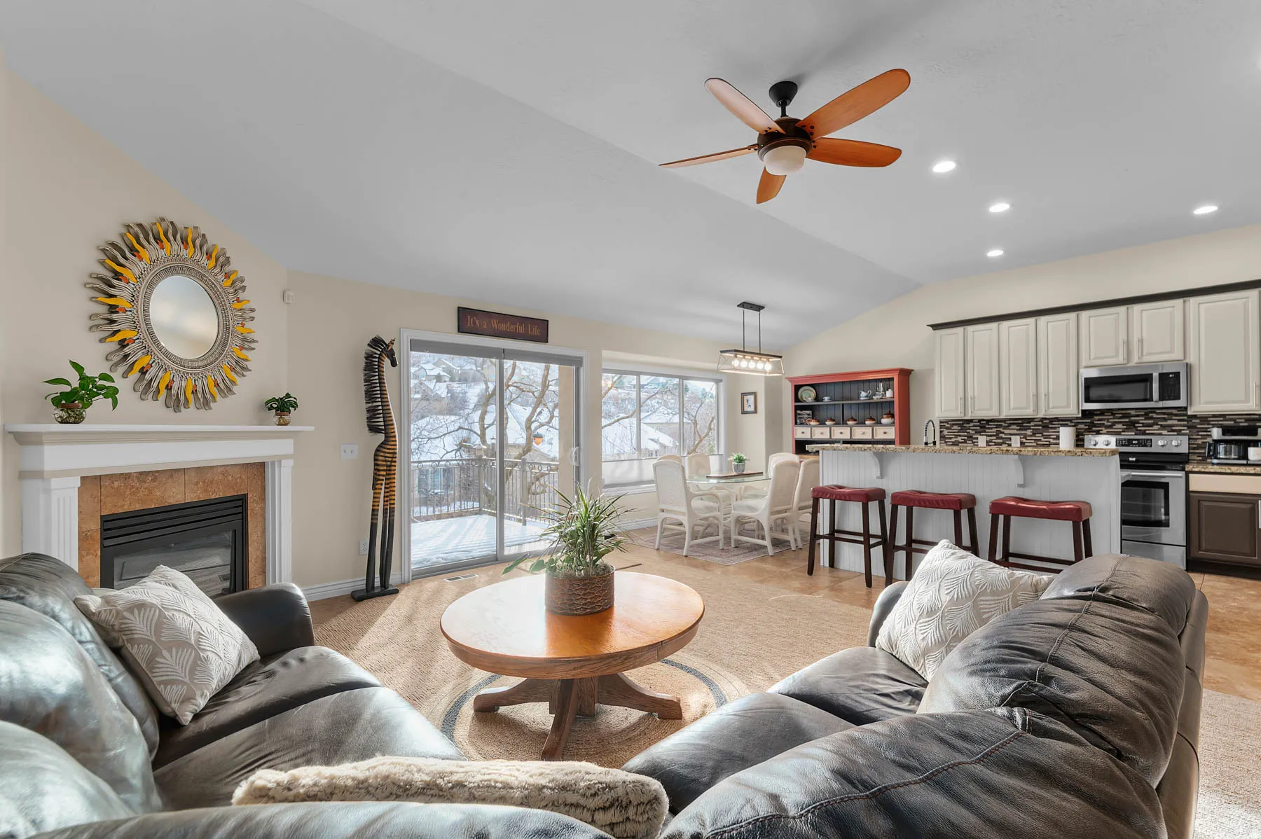 Living area featuring vaulted ceiling, recessed lighting, light colored carpet, a glass covered fireplace, and ceiling fan