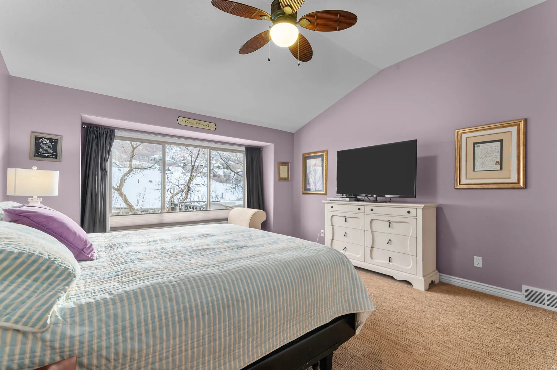 Bedroom featuring vaulted ceiling, light carpet, and ceiling fan
