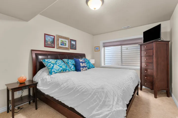 Bedroom with light colored carpet and baseboards