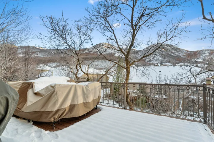 Snow covered deck featuring a mountain view and area for grilling